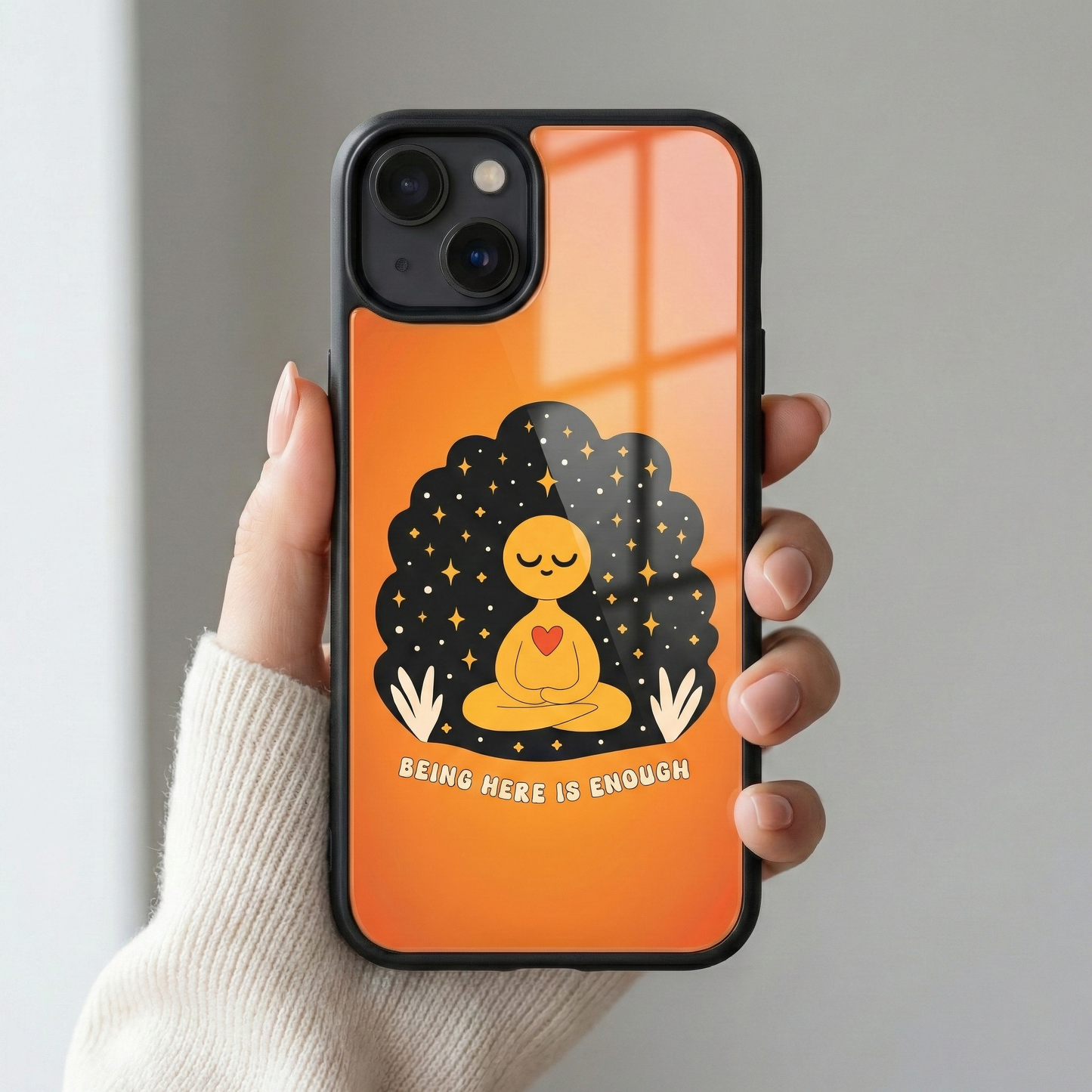 Close up of Being Here Is Enough premium orange glass iPhone case with glossy back finish