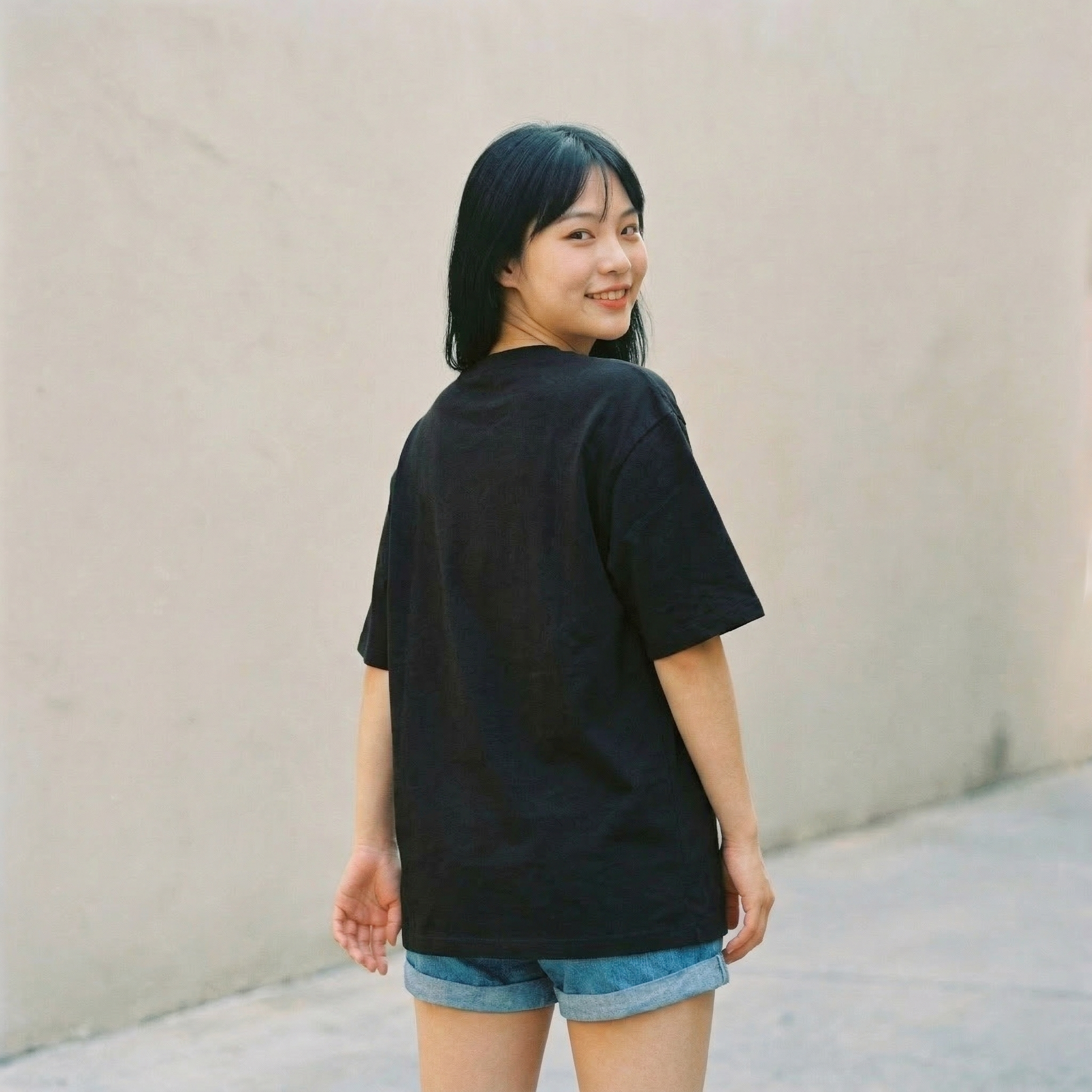 Woman wearing black oversized t-shirt back view with relaxed fit minimal style