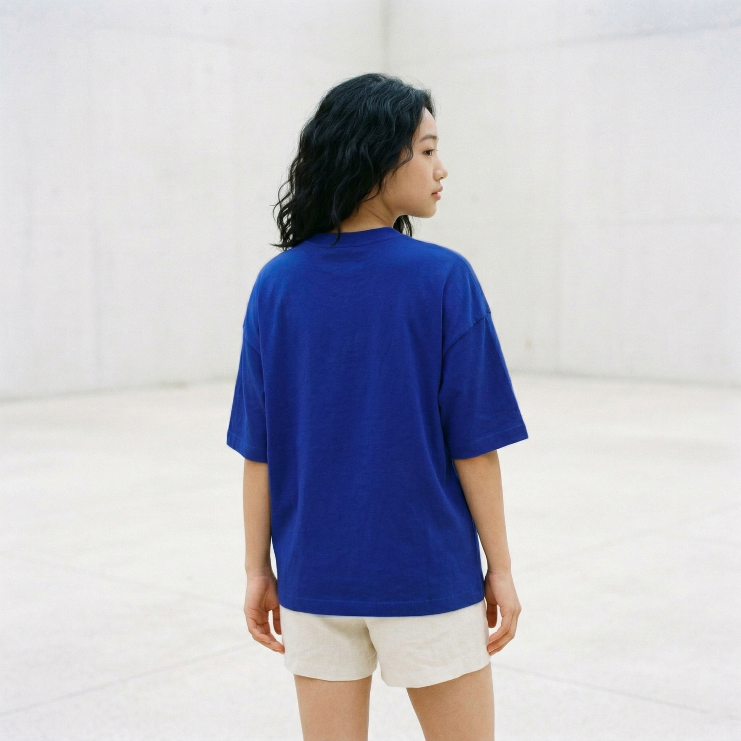 Back view of blue oversized t-shirt worn by woman showing relaxed fit
