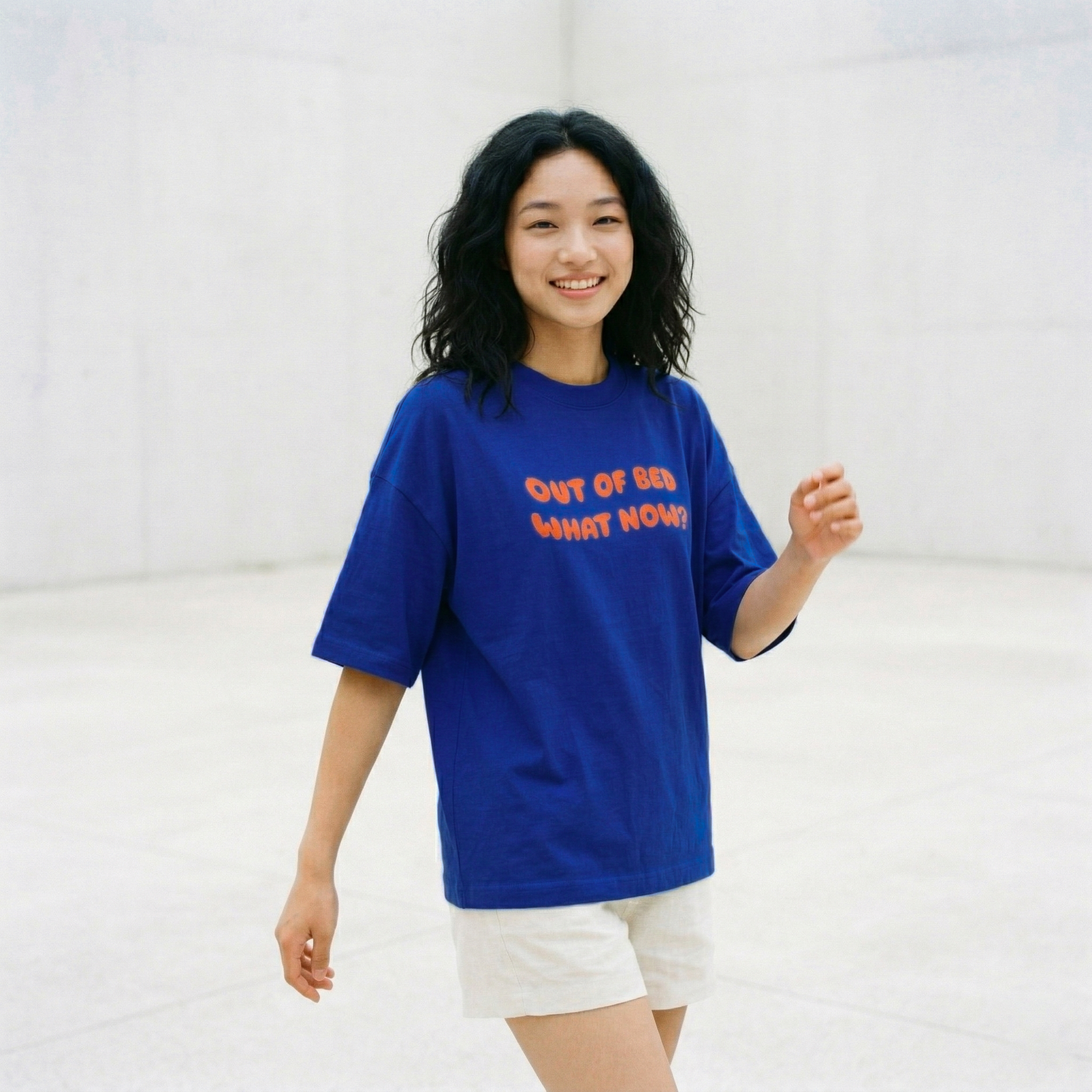 Woman walking wearing blue oversized t-shirt with casual relaxed vibe
