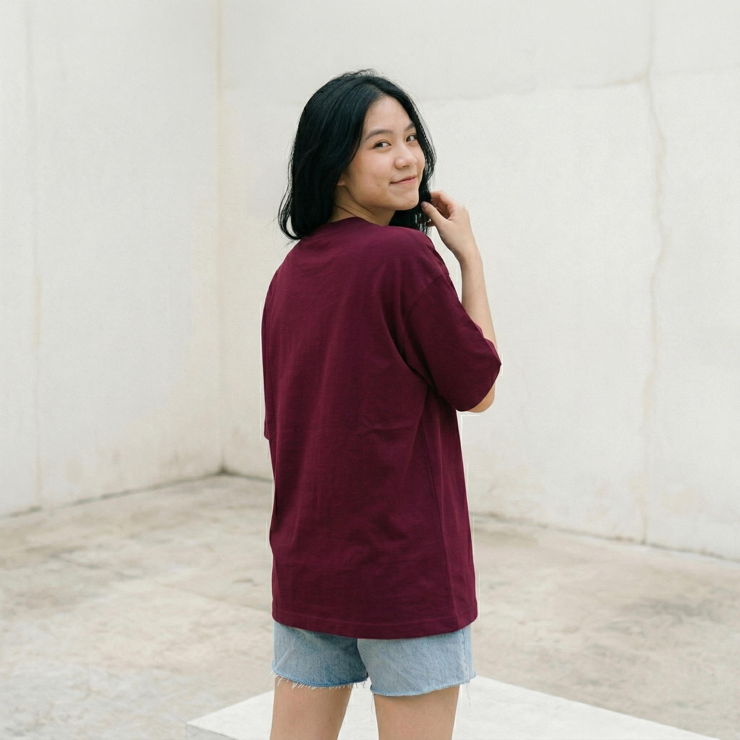 Woman wearing burgundy oversized t-shirt back view oversized fit minimal