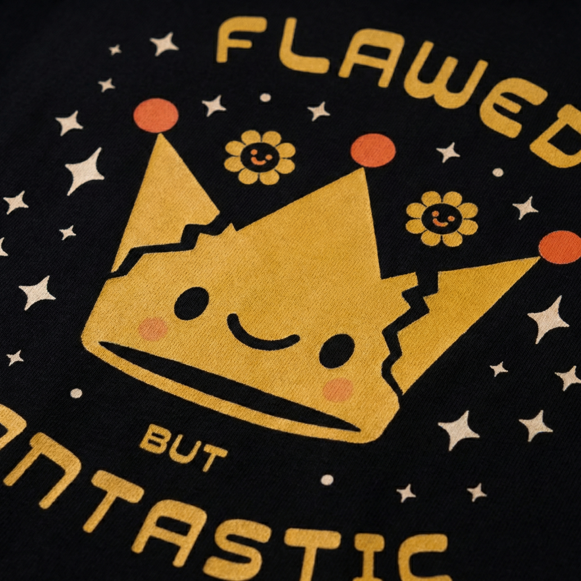 Close-up of yellow crown graphic print on black oversized t-shirt