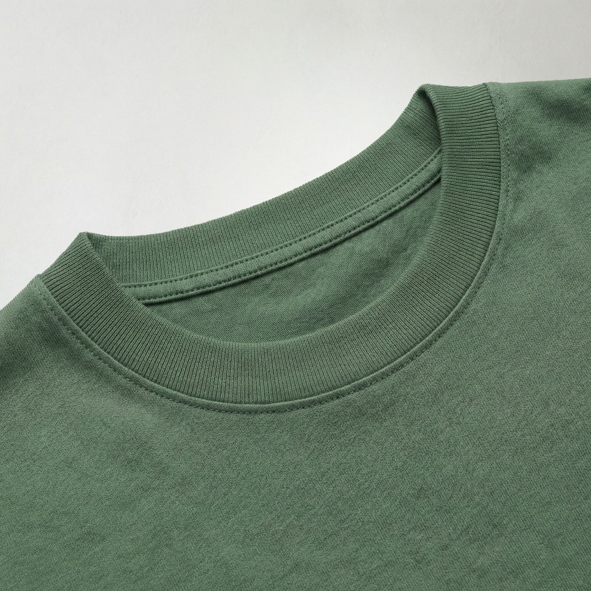 Close up of green oversized cotton t-shirt neckline and fabric texture detail