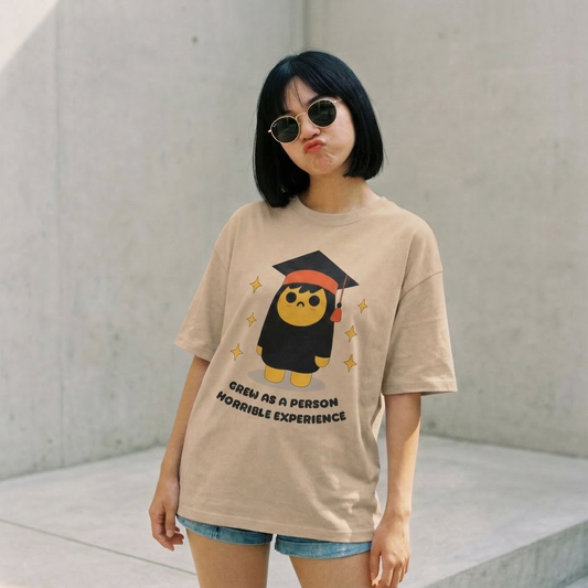 Woman wearing beige oversized t-shirt with funny graduation quote graphic