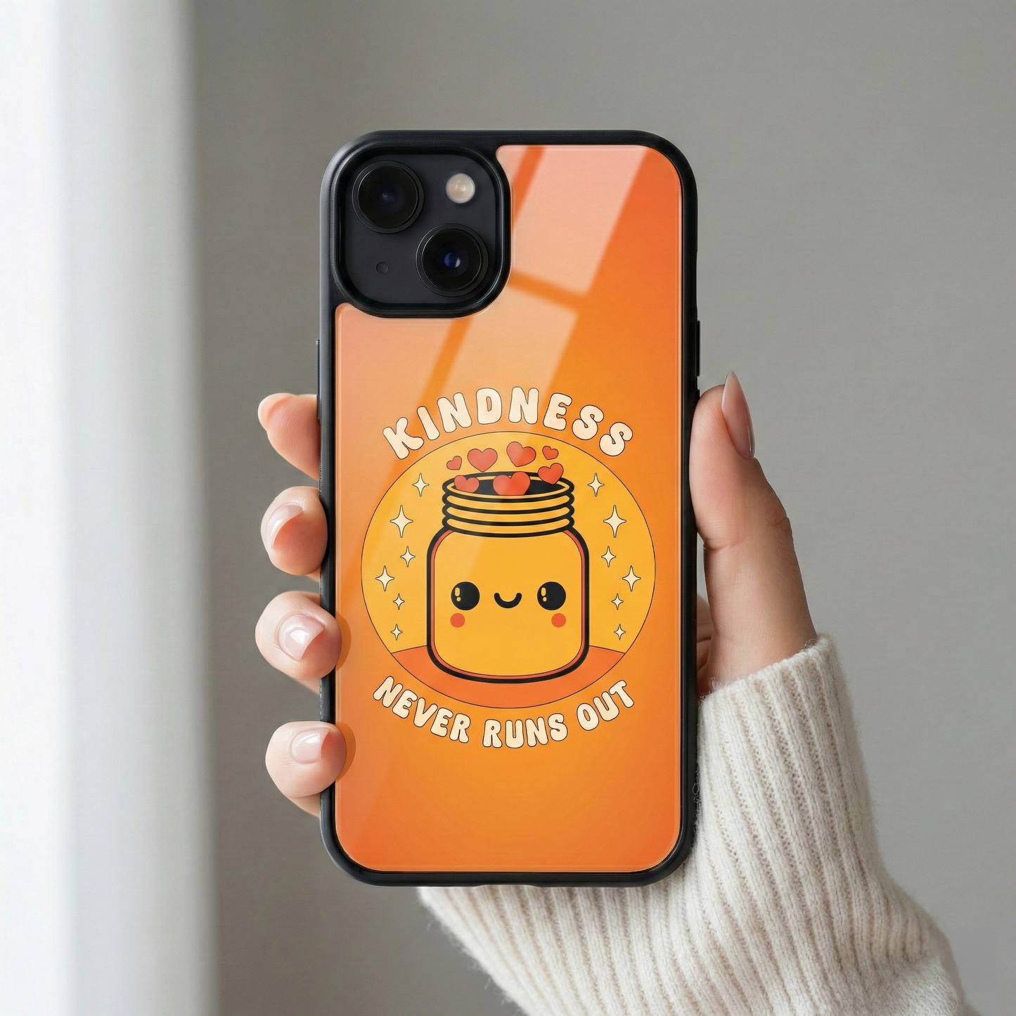 Close up of Kindness Never Runs Out premium orange glass iPhone case with glossy finish