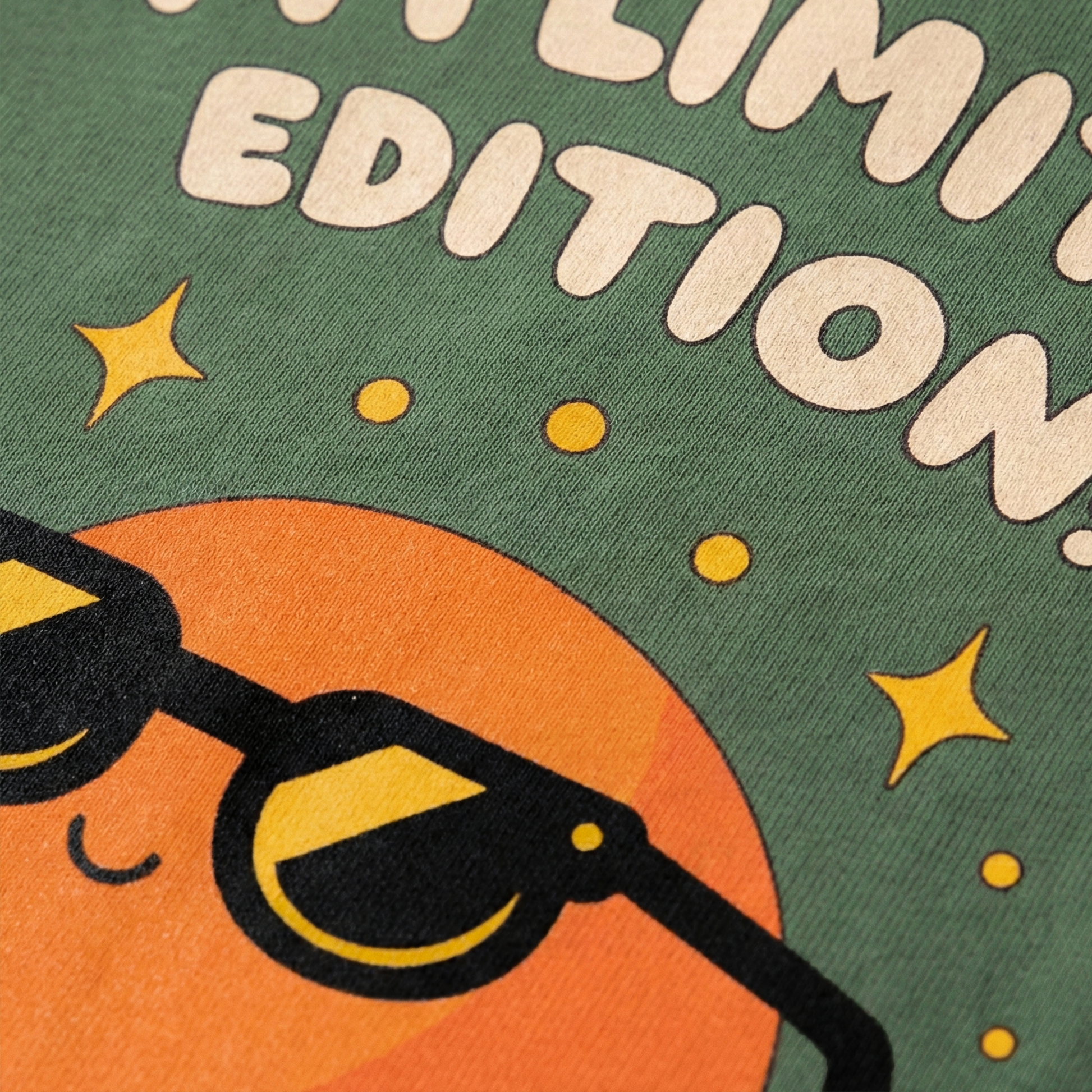 Close-up of orange character with sunglasses print on green oversized t-shirt
