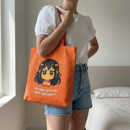 Woman carrying orange canvas tote bag with “My Dog Gets Me But You Don’t” graphic design, casual aesthetic outfit