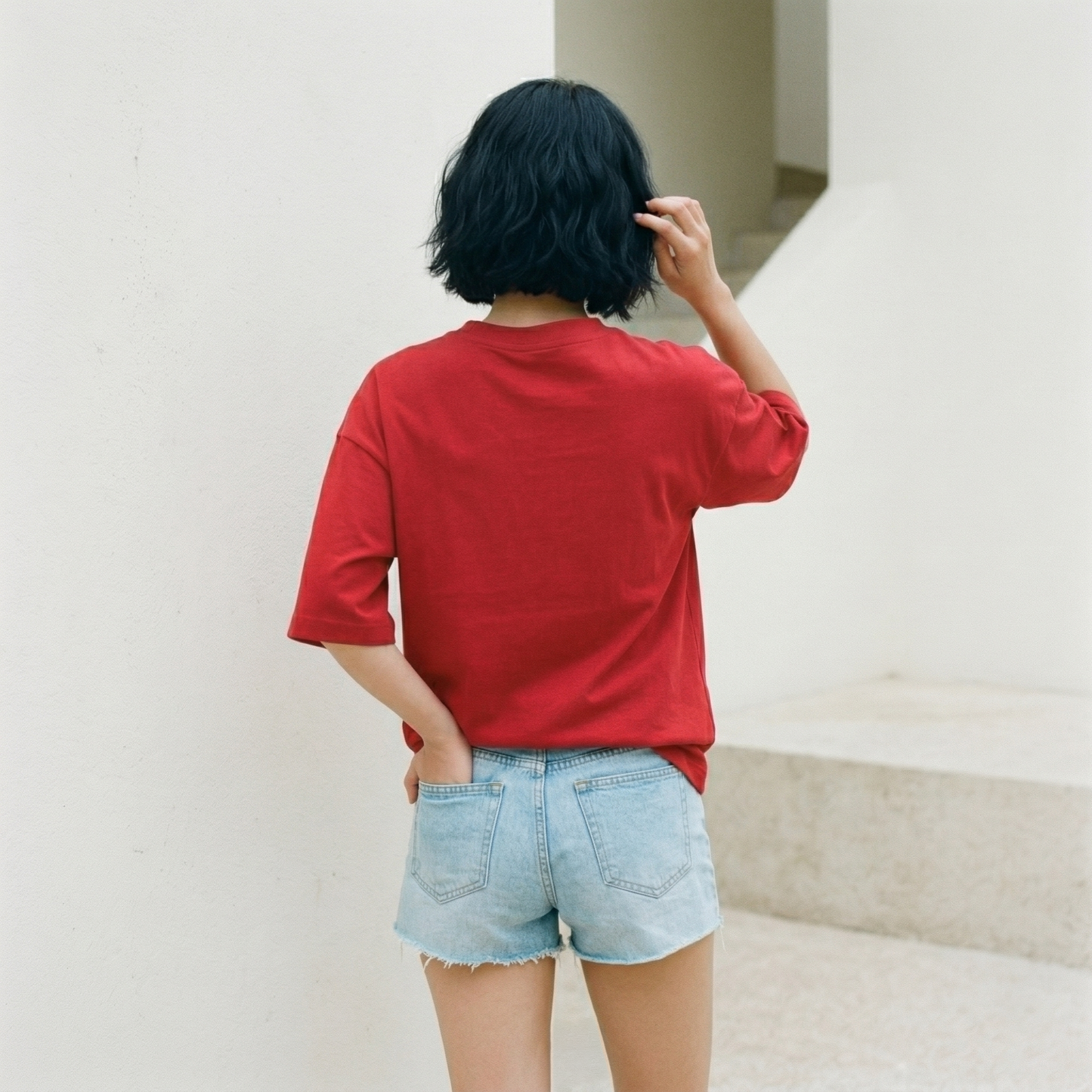 Back view of red oversized t-shirt worn by woman showing relaxed fit