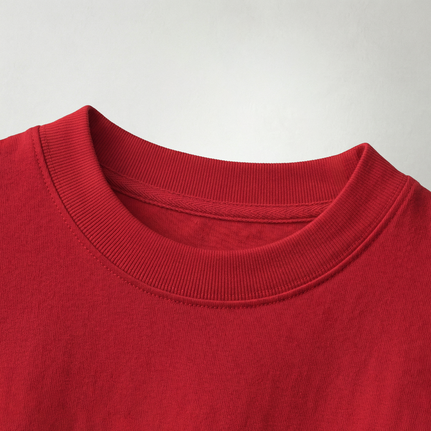 Close-up of red oversized t-shirt fabric and neckline showing soft cotton texture and stitching