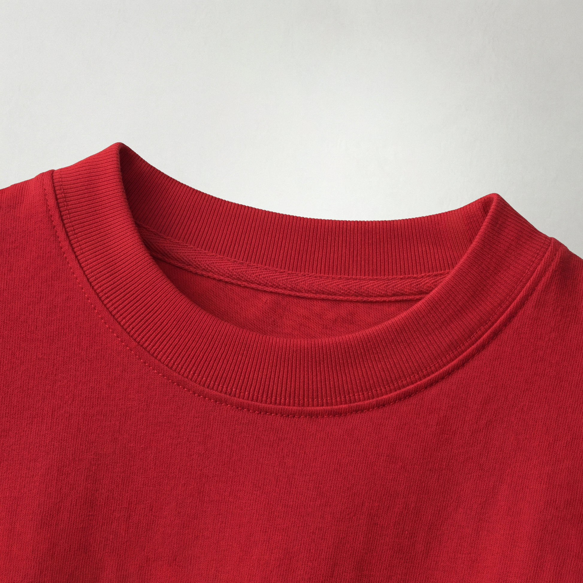 Close-up of red oversized t-shirt fabric and neckline showing soft cotton texture and stitching