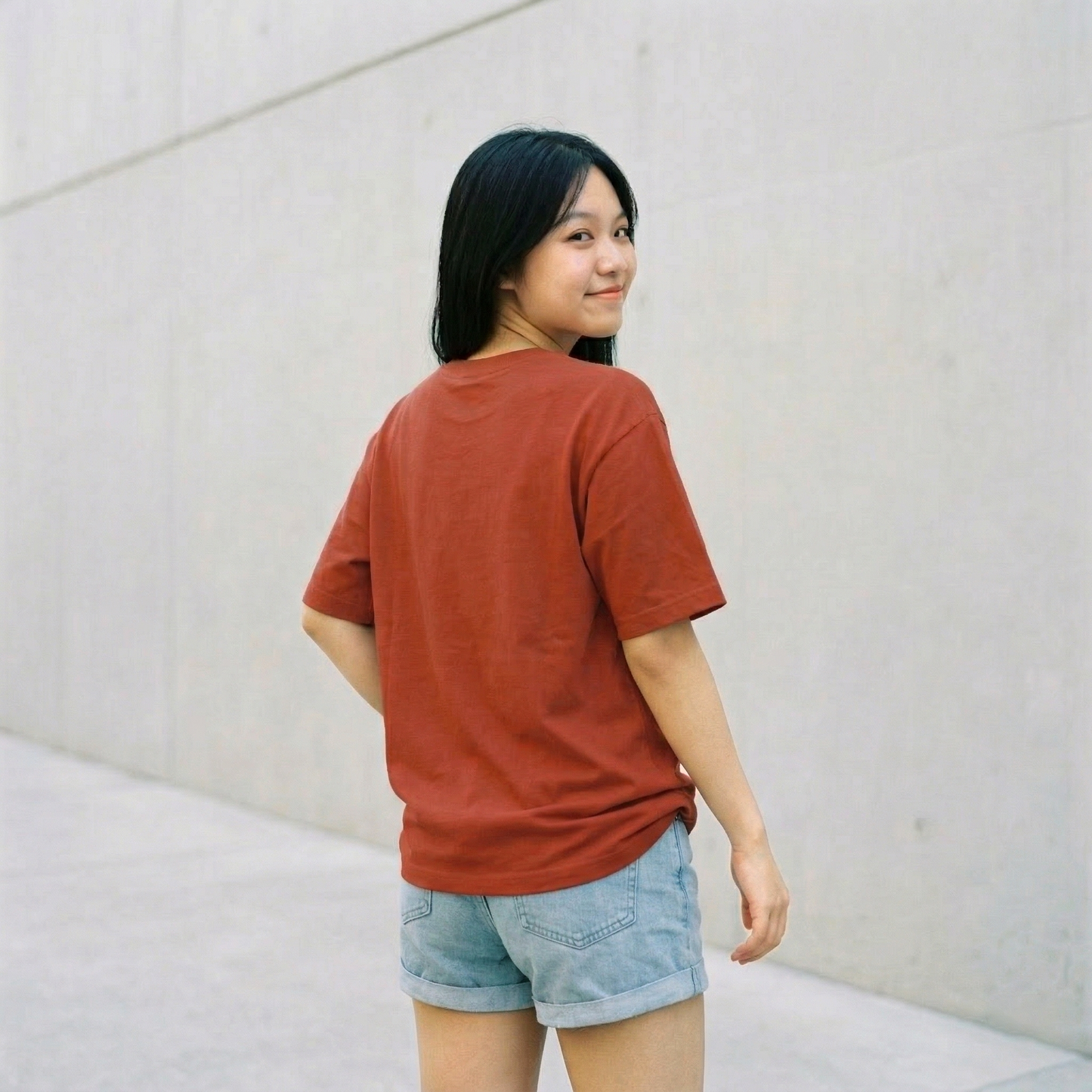 Woman wearing rust oversized t-shirt back view relaxed fit casual minimal look