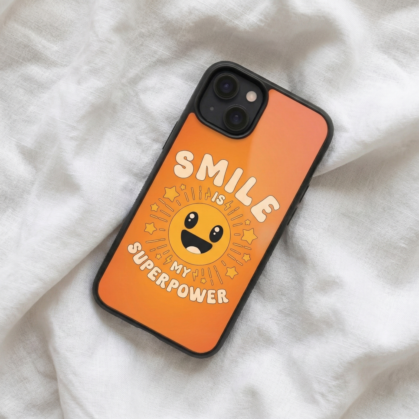 Smile Is My Superpower orange glass iPhone case by Spiritual Kalakaar with happy sun illustration placed on soft fabric background